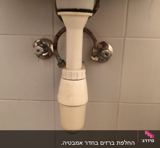 צינור מתחת לכיור עם ברזים וחיבורים